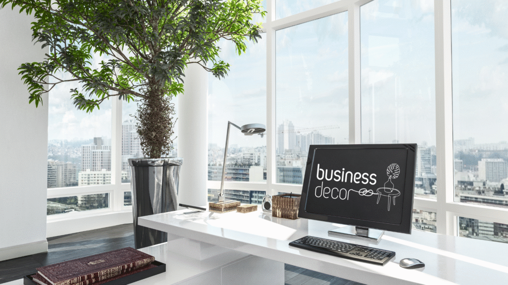 Oficina moderna con escritorio blanco, planta natural y ordenador con logotipo de Business Decor, representando la identidad visual de la consultoría.